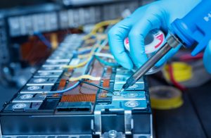 Technician use soldering iron to solder metal and wire of lithiu